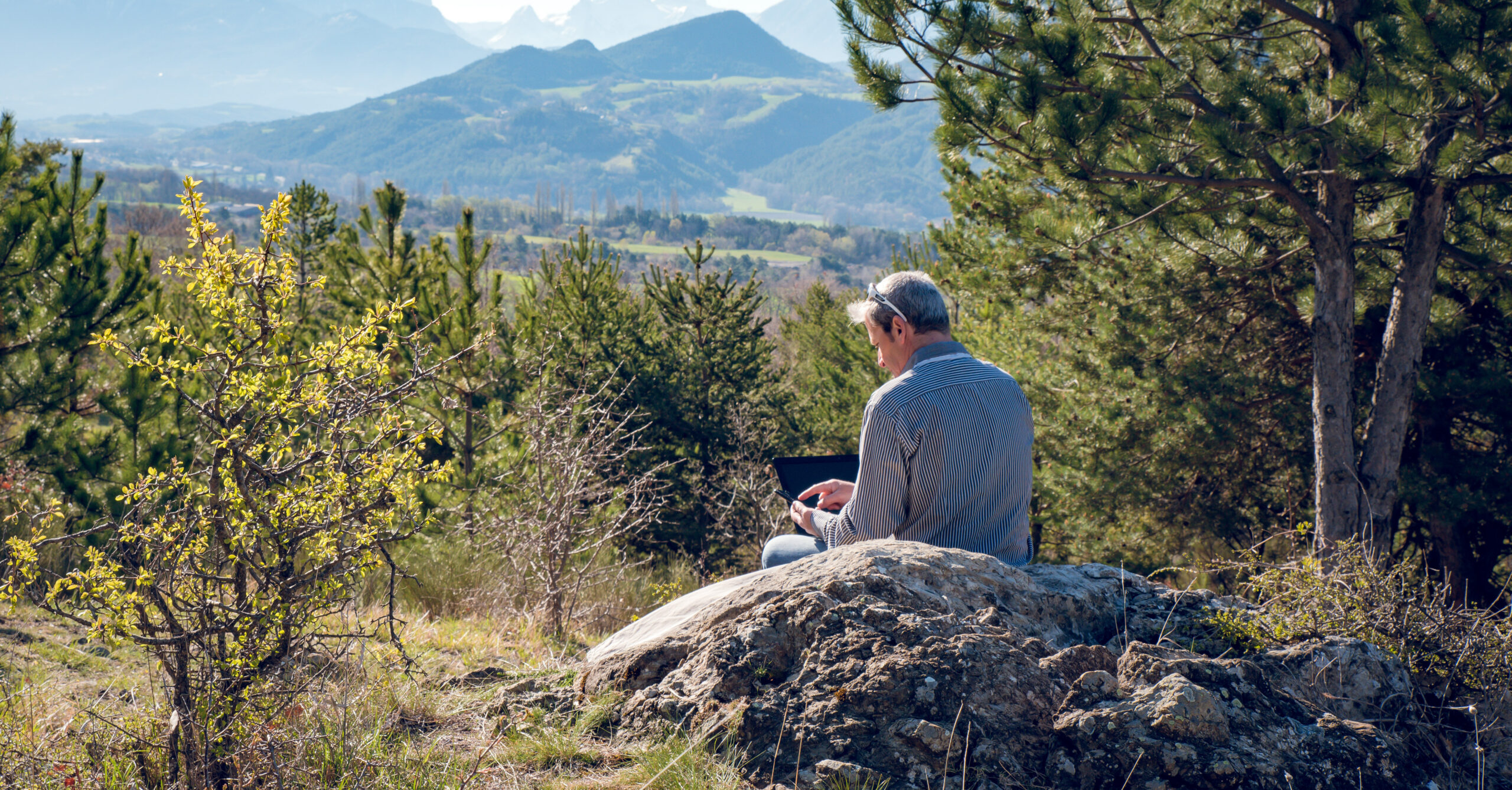 Homme qui travail sur son ordinateur portable en pleine nature d
