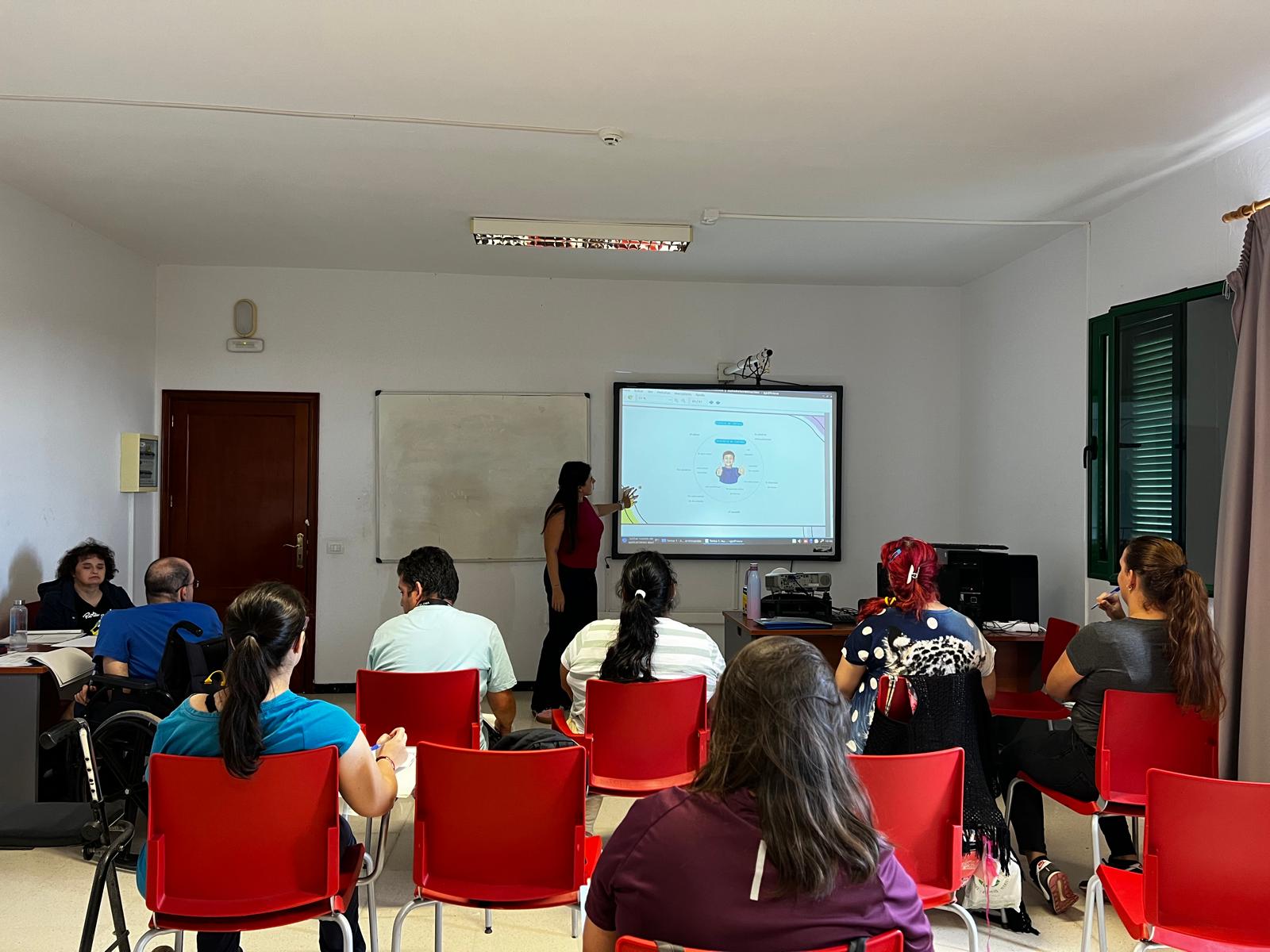 Un aula con alumnos y alumnas. La persona docente está explicando una de las formaciones del proyecto.